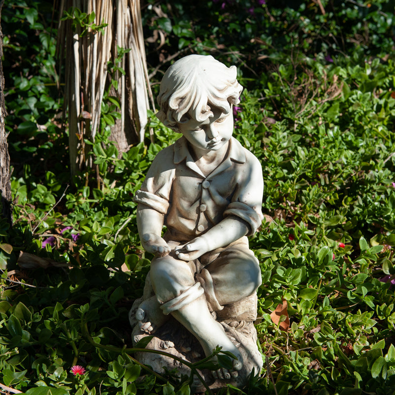 Boy Sitting On Rock Statue